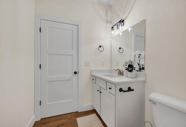 bathroom with vanity, hardwood / wood-style floors, and toilet