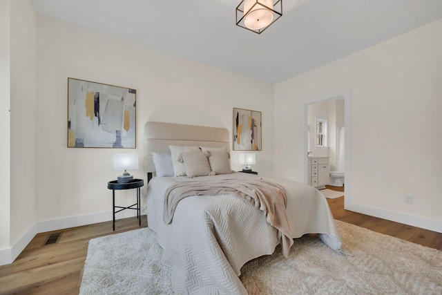 bedroom featuring ensuite bathroom and light hardwood / wood-style flooring