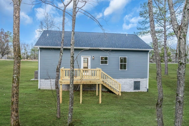 back of property featuring a wooden deck and a yard