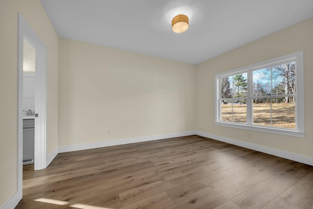 empty room featuring sink and light hardwood / wood-style floors