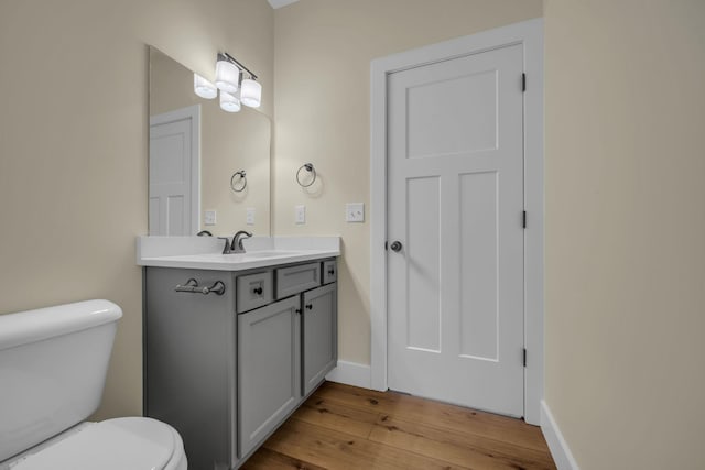 bathroom with vanity, toilet, and hardwood / wood-style floors