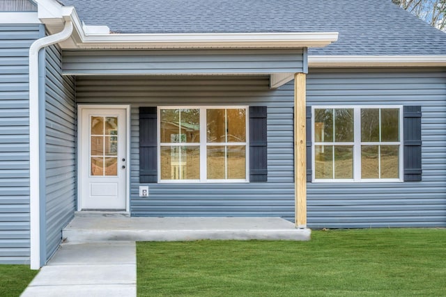 view of exterior entry featuring a yard