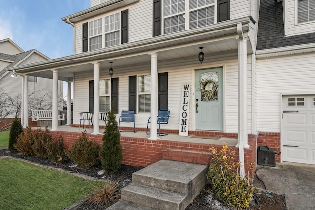 doorway to property with a porch and a garage