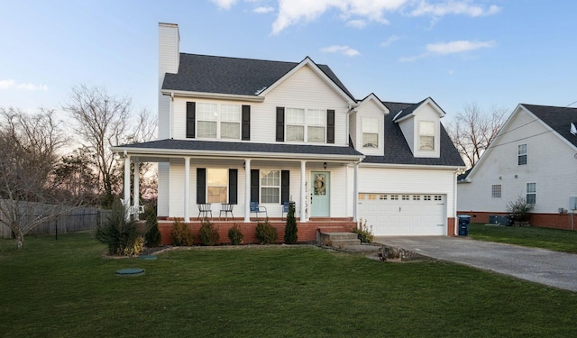 view of front of home with a garage, a yard, and covered porch