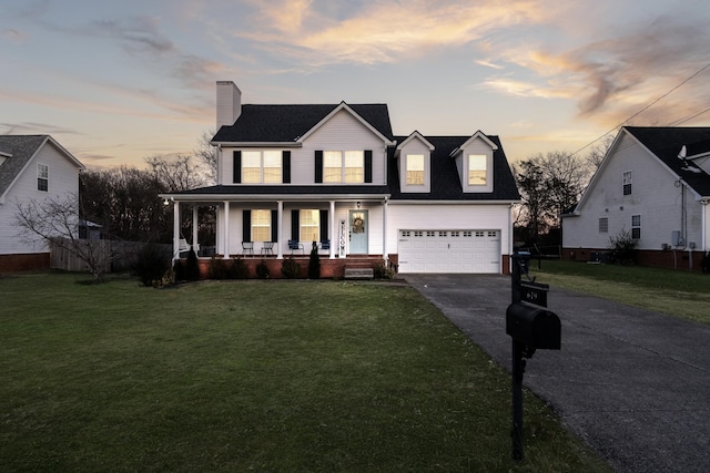 view of front of property featuring a porch, a yard, and a garage