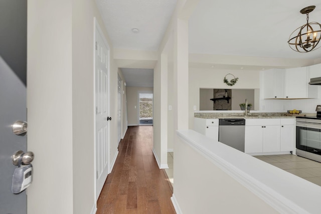 corridor with hardwood / wood-style floors and a chandelier