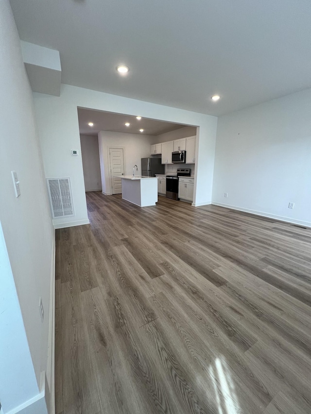 302 Williams Ave Unit 110, Madison, TN 37115 - unfurnished living room with a sink, visible vents, baseboards, recessed lighting, and wood finished floors