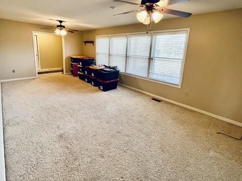 unfurnished room featuring plenty of natural light, carpet floors, and ceiling fan