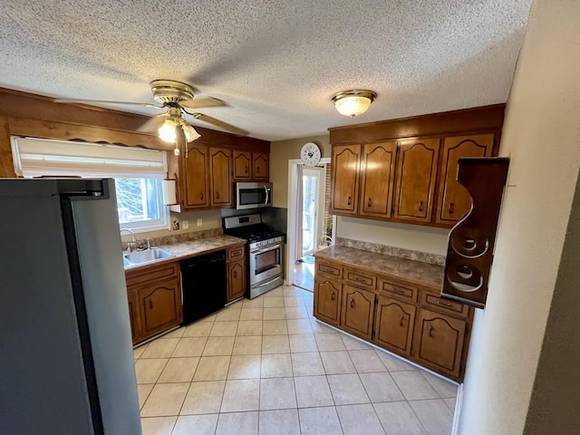 kitchen featuring sink, stainless steel appliances, ceiling fan, and a textured ceiling