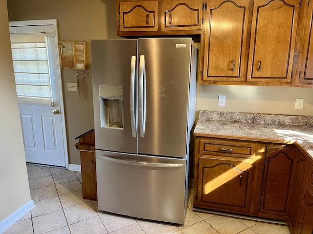 kitchen featuring stainless steel refrigerator with ice dispenser and light tile patterned floors