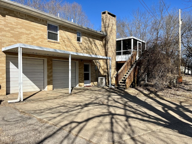 back of house with a garage and a sunroom