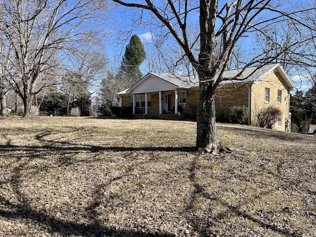 ranch-style home with covered porch and a front lawn