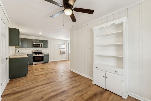 kitchen featuring appliances with stainless steel finishes, sink, cooling unit, hardwood / wood-style flooring, and crown molding