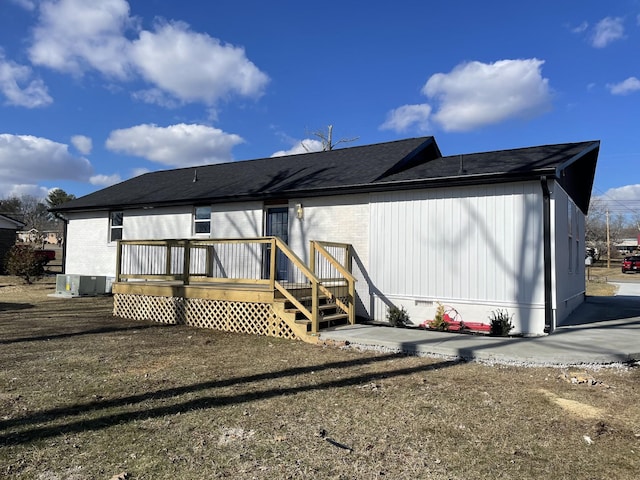 rear view of house with a deck and a yard