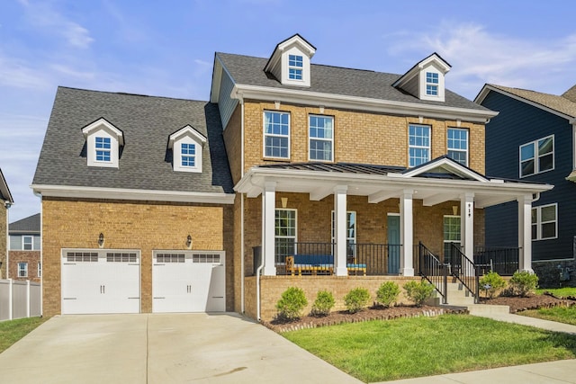 view of front facade with covered porch, a garage, and a front lawn