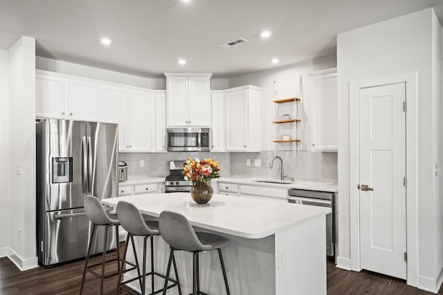 kitchen featuring white cabinets, stainless steel appliances, and a kitchen island