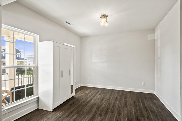 unfurnished room with dark hardwood / wood-style flooring