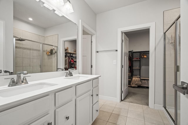 bathroom with a shower with shower door, tile patterned floors, and vanity