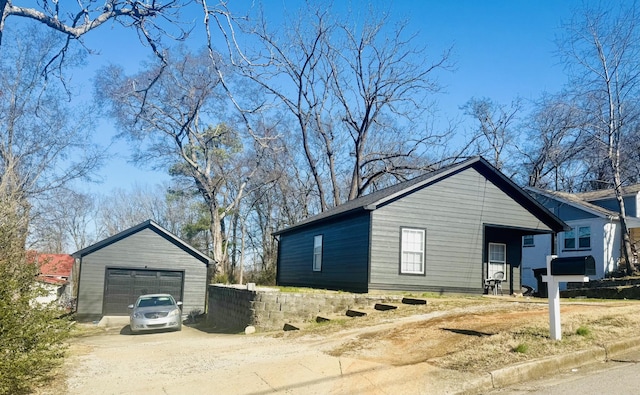 view of side of property featuring a garage and an outbuilding