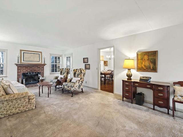 carpeted living room with a brick fireplace, an inviting chandelier, and a healthy amount of sunlight