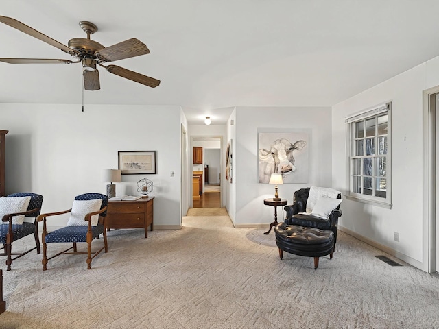 living area with ceiling fan and light carpet