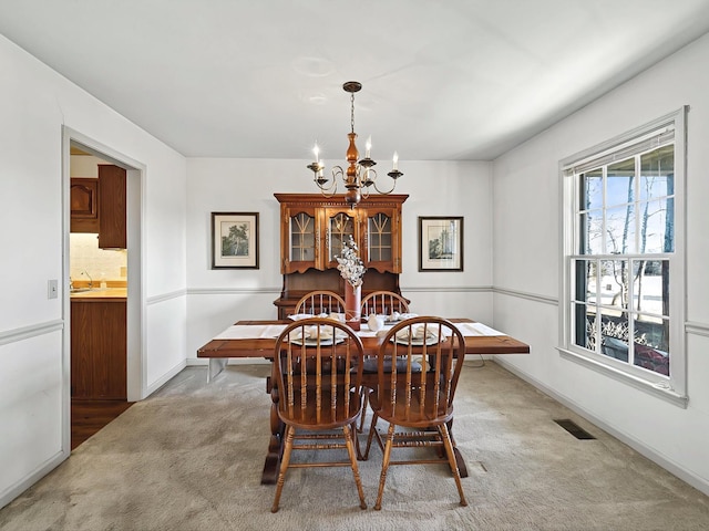 dining room featuring carpet and a notable chandelier