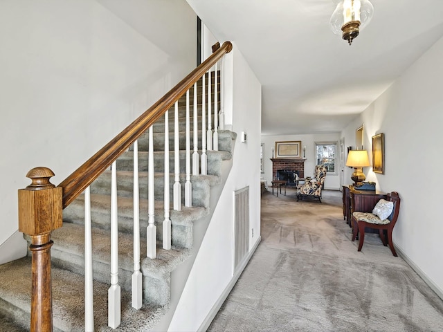 staircase featuring carpet flooring and a fireplace