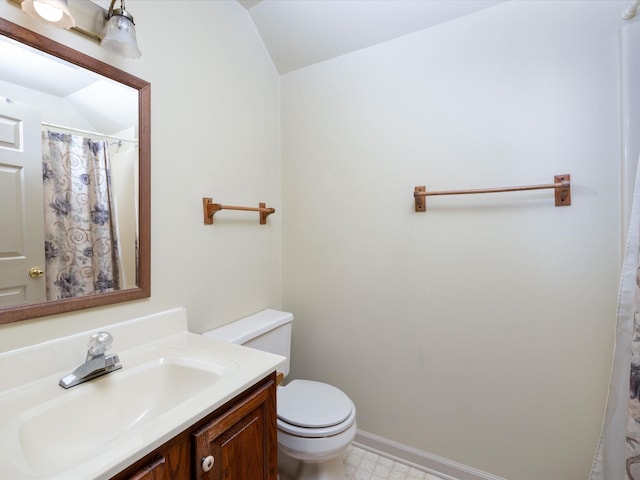 bathroom featuring vanity, toilet, and lofted ceiling