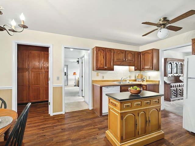 kitchen featuring a center island, white appliances, sink, dark wood-type flooring, and ceiling fan