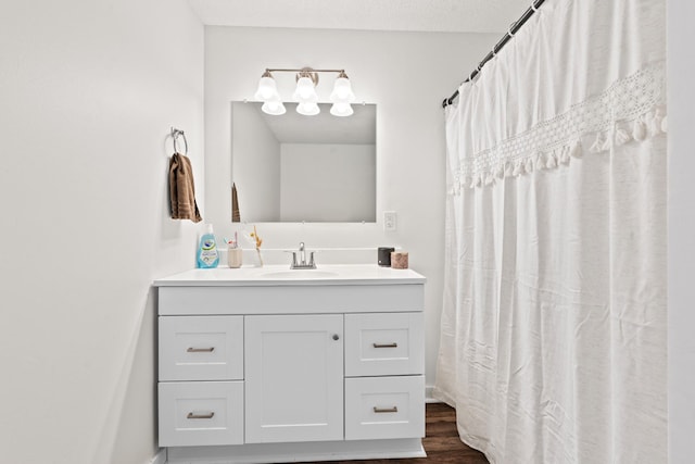 bathroom featuring a shower with curtain, hardwood / wood-style floors, a textured ceiling, and vanity