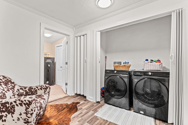 laundry room featuring ornamental molding, light hardwood / wood-style floors, a textured ceiling, and independent washer and dryer