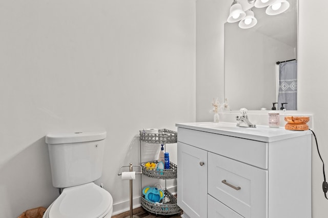 bathroom featuring toilet, vanity, and a shower with shower curtain