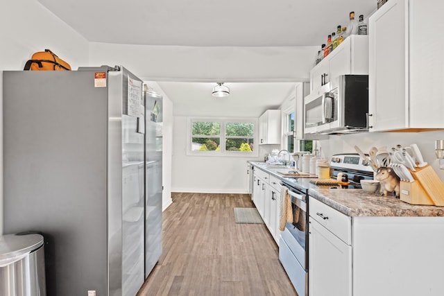 kitchen featuring white cabinets, stainless steel appliances, light hardwood / wood-style flooring, and sink