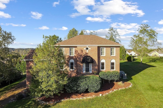 view of front of home with a front yard and central AC unit