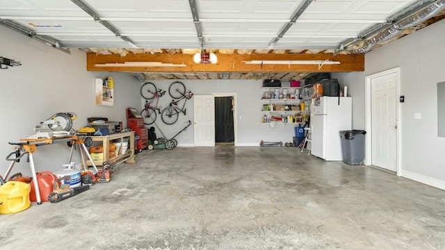 garage featuring white refrigerator and electric panel