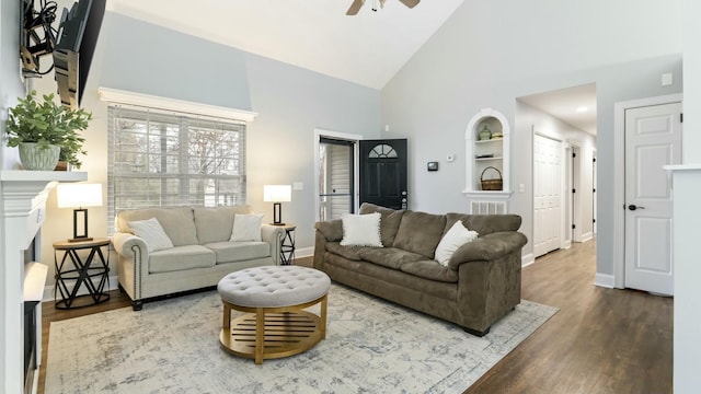 living room with built in features, hardwood / wood-style flooring, high vaulted ceiling, and ceiling fan