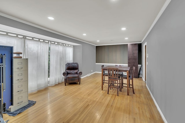 dining area featuring light hardwood / wood-style floors and crown molding