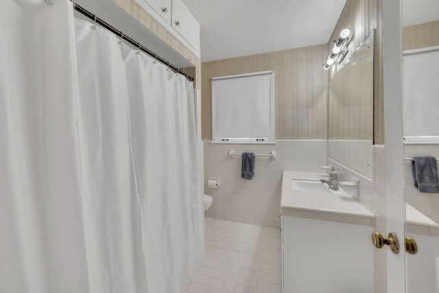 bathroom featuring tile walls, toilet, vanity, and tile patterned flooring