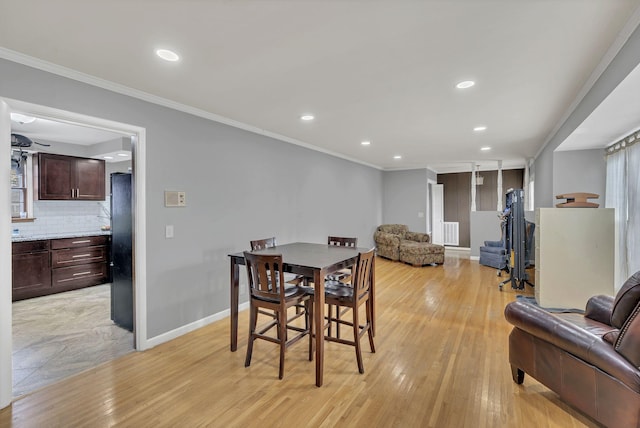 dining room featuring ornamental molding and light hardwood / wood-style flooring