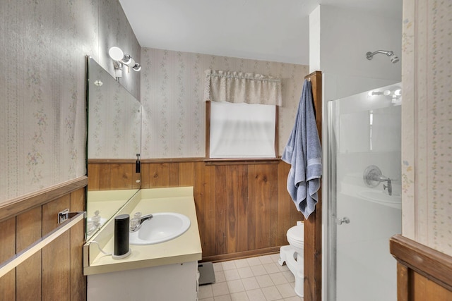 bathroom with vanity, toilet, wood walls, and walk in shower