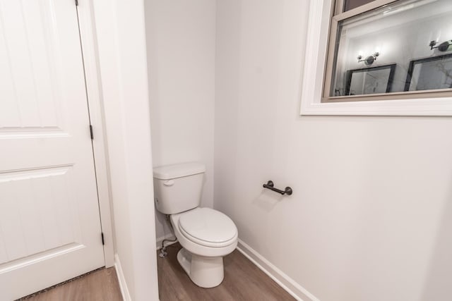 bathroom featuring baseboards, toilet, and wood finished floors