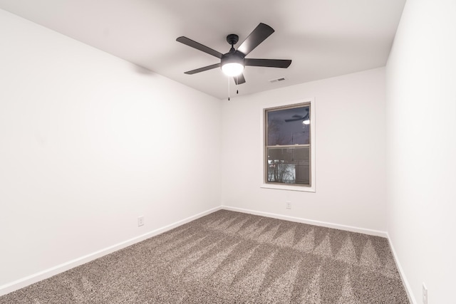 carpeted spare room featuring ceiling fan, visible vents, and baseboards