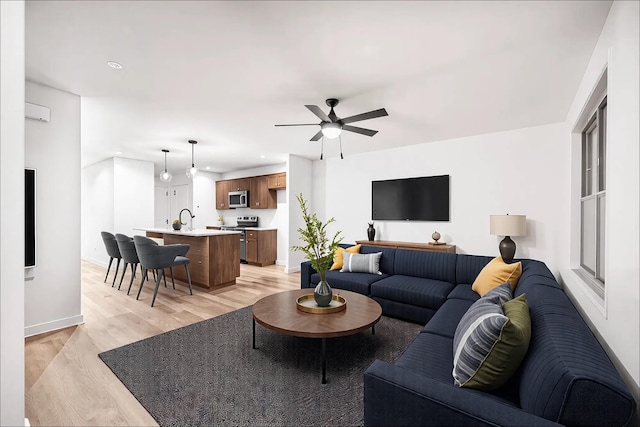 living area featuring ceiling fan, recessed lighting, light wood-style flooring, and baseboards