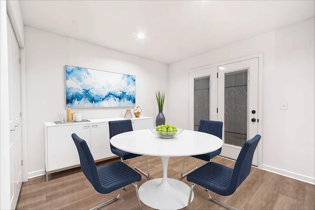 dining room with recessed lighting, light wood-style flooring, and baseboards