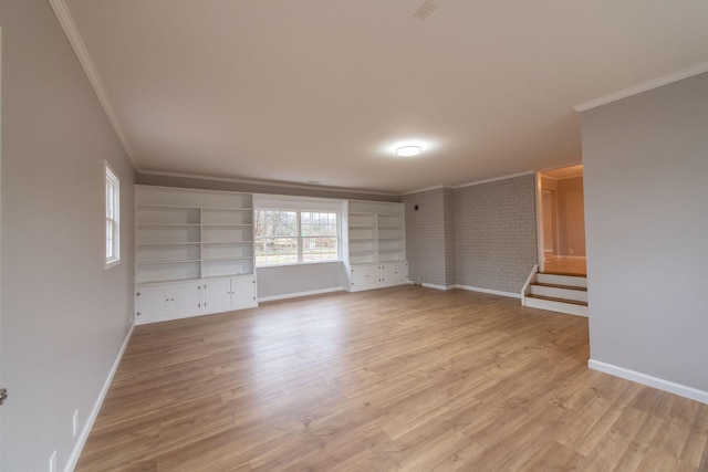 unfurnished living room with crown molding, light wood-type flooring, and brick wall