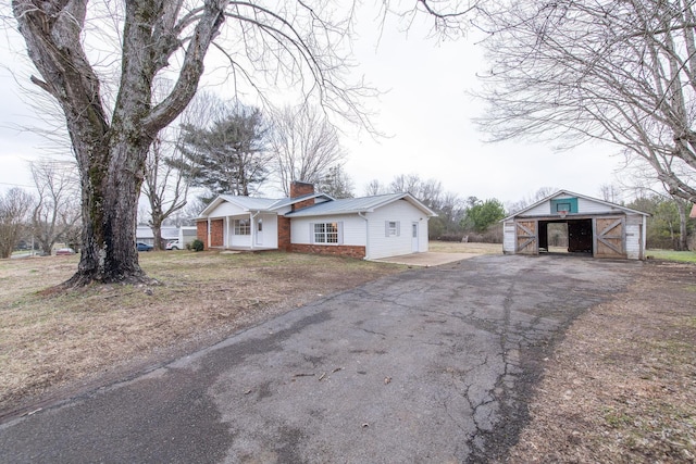 single story home with an outdoor structure and a garage