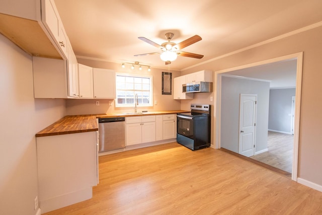 kitchen with ornamental molding, wooden counters, white cabinets, and stainless steel appliances