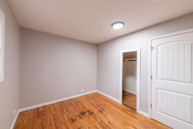 unfurnished bedroom featuring a closet and light wood-type flooring