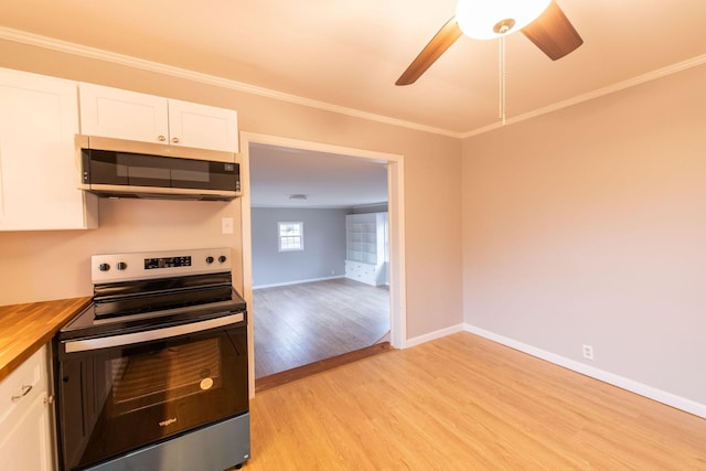 kitchen with white cabinets, light hardwood / wood-style flooring, butcher block counters, and appliances with stainless steel finishes