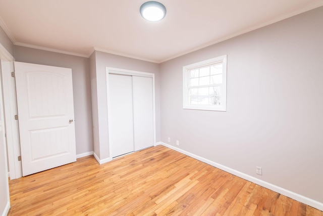 unfurnished bedroom featuring a closet, crown molding, and light hardwood / wood-style flooring